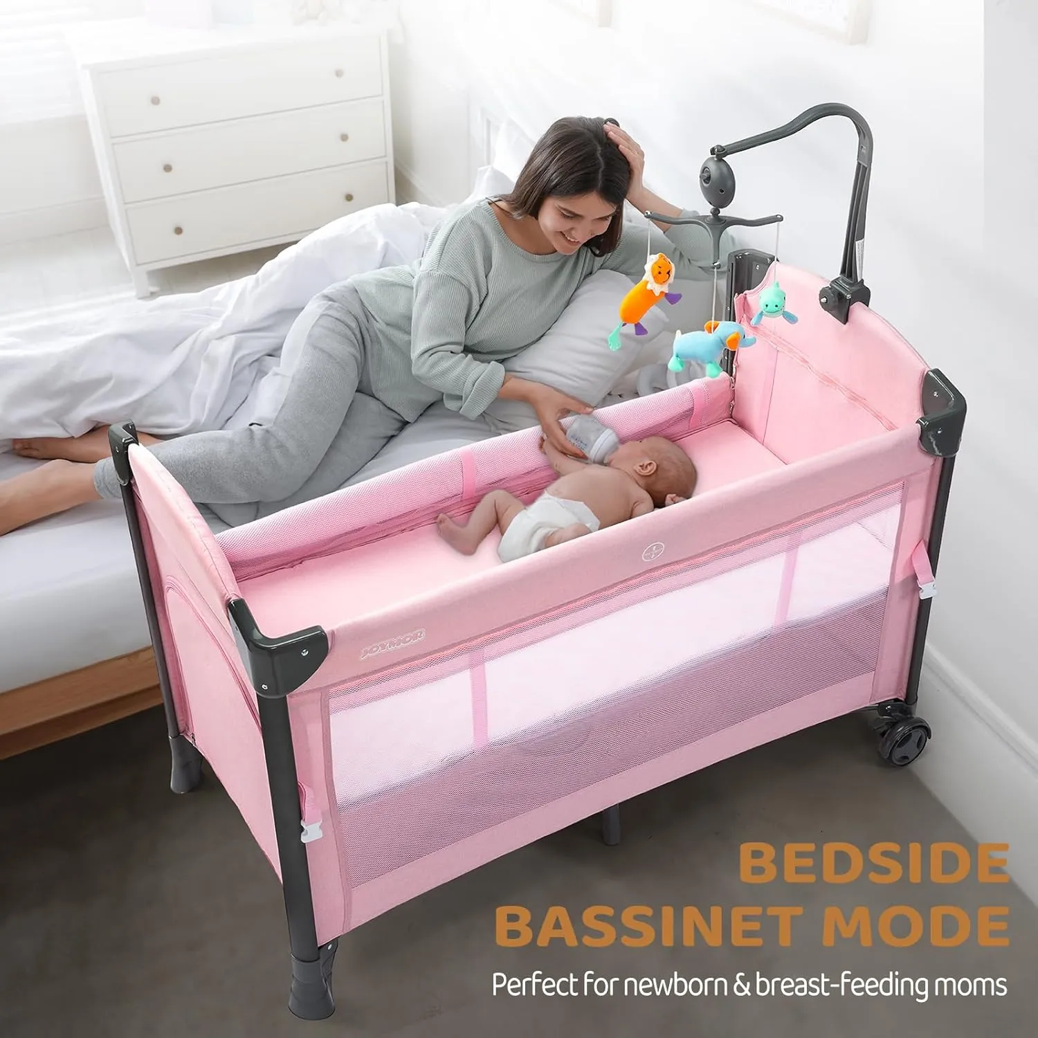 JOYMOR Baby Bedside Bassinet, Baby Bassinet, Pack n Play Convert Playpen, Quick Foldable Travel Bed with Toy, Wheels & Brake, Carry Bag for Boys Girls (Pink)